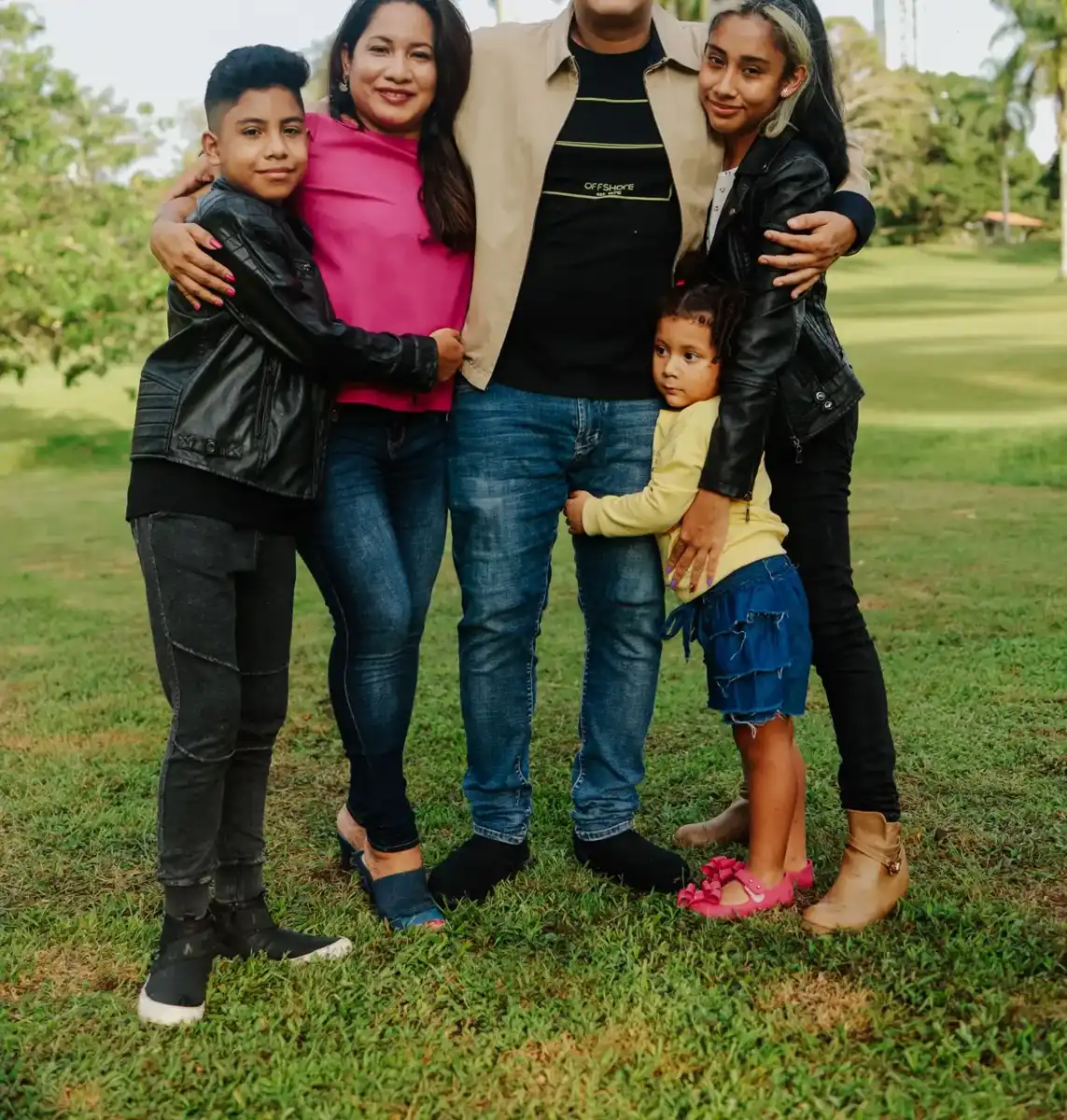 Family smiling together outside their home